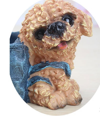 Small curly brown puppy figurine with big black eyes and a blue denim backpack.