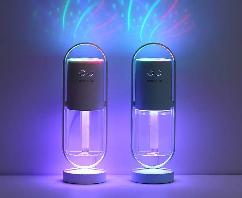 Two sleek black USB ultrasonic humidifiers with glowing bases and colorful projection night lights displaying star and wave.