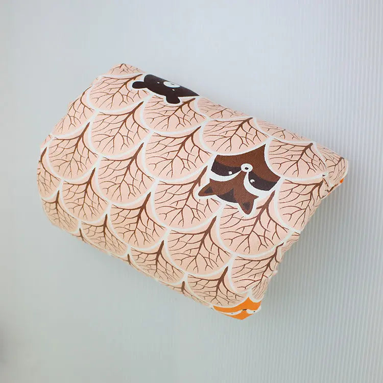 Beige nursing arm pillow with brown and orange leaf and bird pattern, U-shaped, soft cotton fabric.