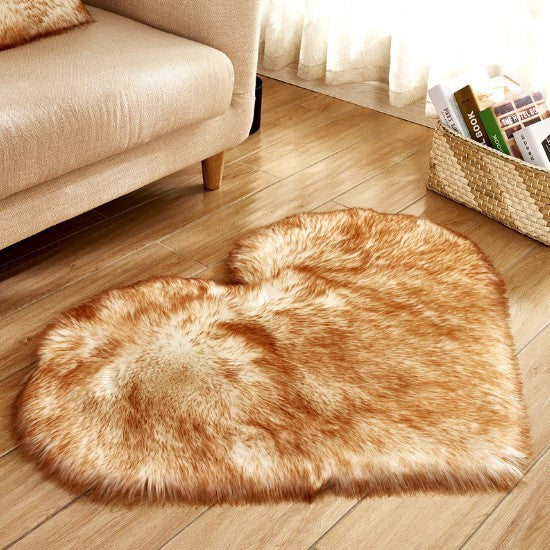 Heart-shaped plush rug in warm golden brown with fluffy texture on wooden floor by beige sofa.