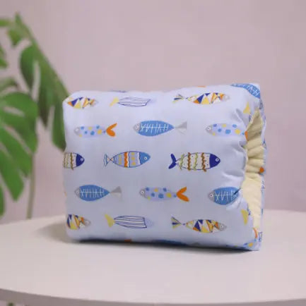 White nursing arm pillow with blue and orange fish pattern and soft cotton fabric.