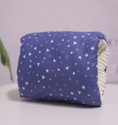 Deep blue nursing arm pillow with small white stars and pink circular patterns, elastic beige strap visible.