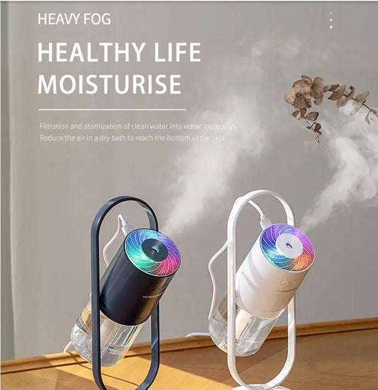 Black USB air humidifier with colorful projection light and mist output on wooden surface.