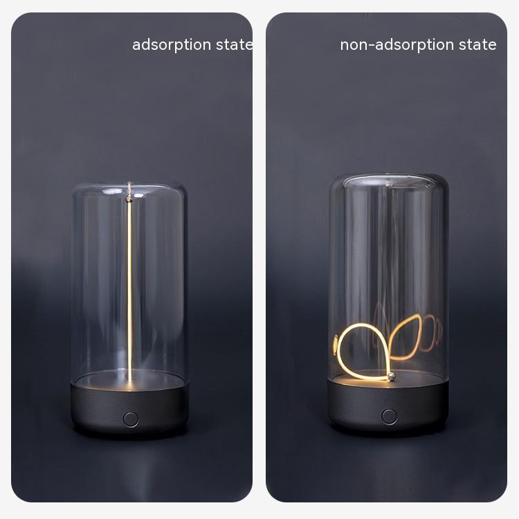 Dark grey portable LED camping light with transparent cylindrical cover and glowing decorative filament inside.