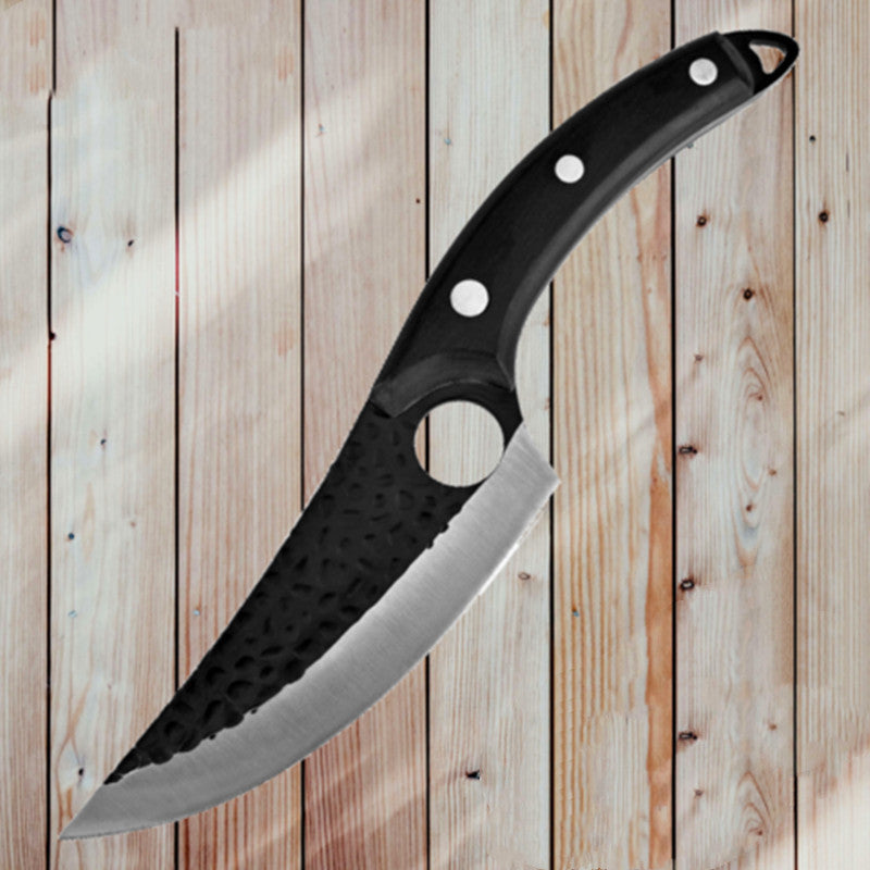 Black handled curved meat boning knife with textured blade and finger hole on wooden background.