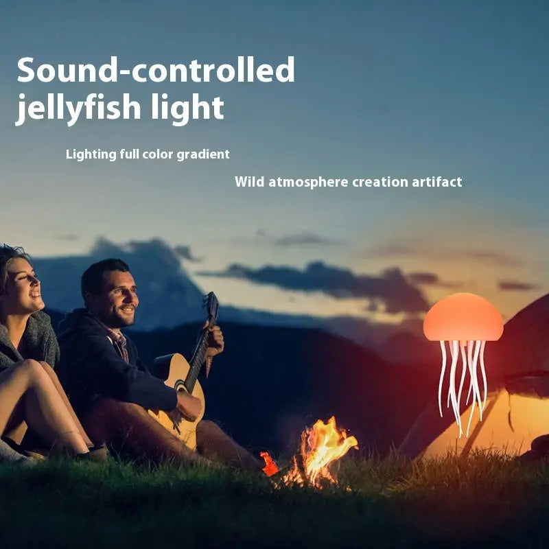 Orange glowing jellyfish-shaped LED lamp floating above campfire at dusk with two people sitting nearby.