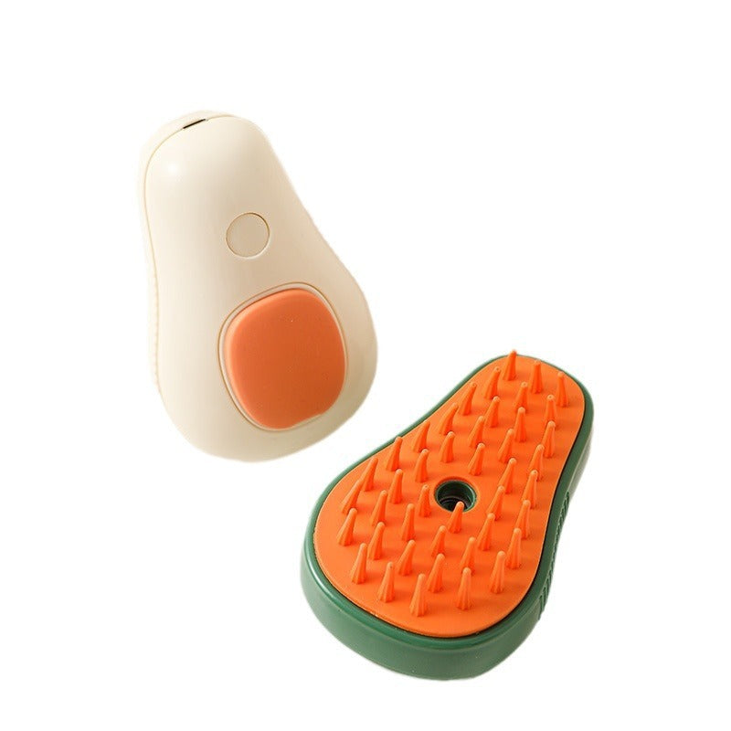 Cream white avocado-shaped electric cat brush with orange silicone grip and green and orange spiked grooming comb.